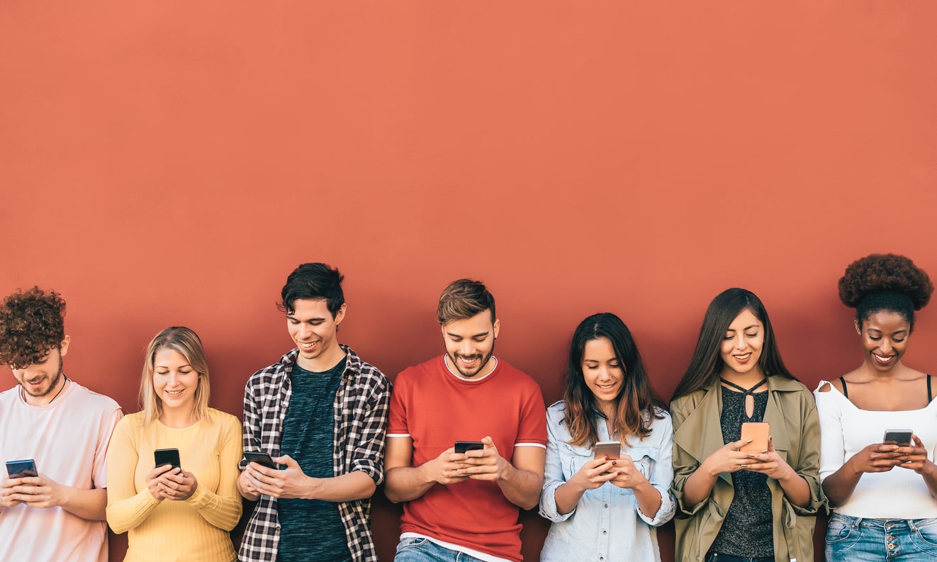 A concept of brand positioning; a group of Gen Z consumers against a wall using their mobile phones for online shopping